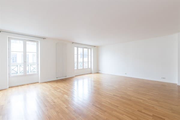 Empty living room with wood flooring and a glass balcony door before AI interior design