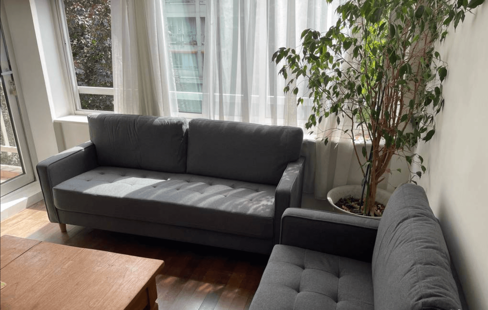Living room with a dark grey sofa before an AI interior design furniture swap